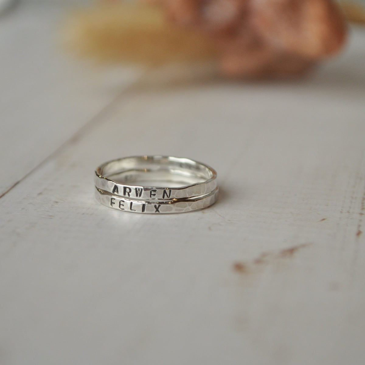 Silver ring with engraved text on a white surface