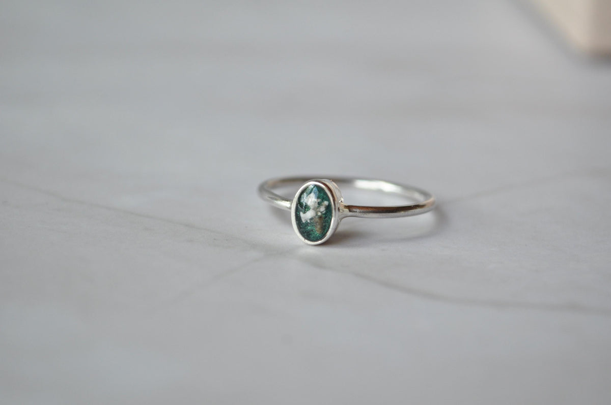 Small oval memorial ring showing the slender silver band | Mila Faith