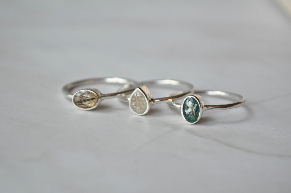 Three silver Mila Faith ashes keepsake rings with different coloured inlays.