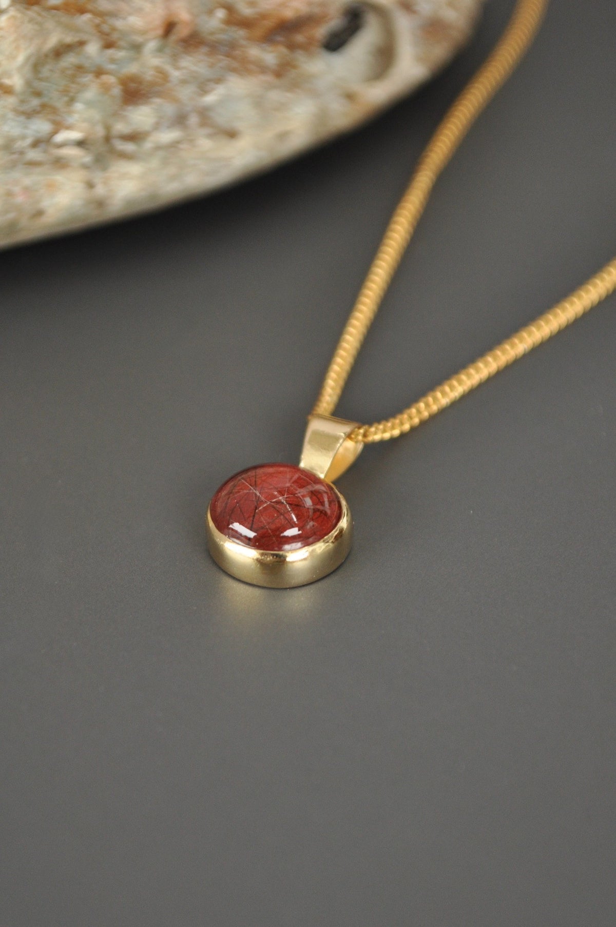 Gold-tone cremation ashes pendant necklace styled with a textured display.